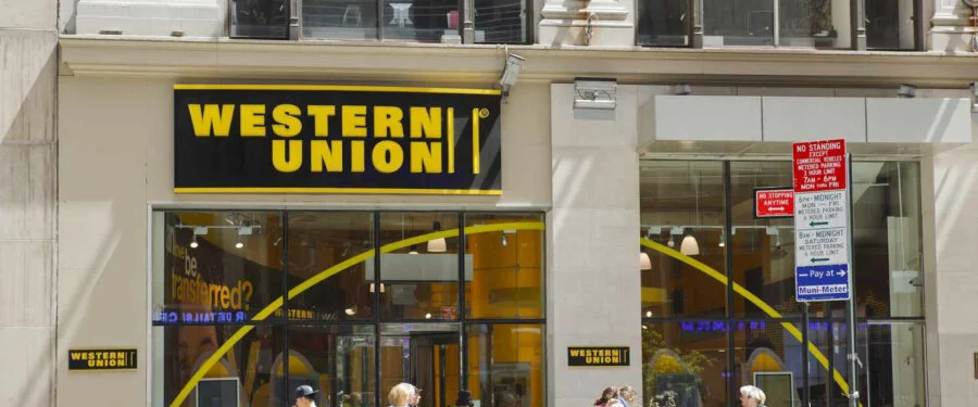 Western Union branch storefront with pedestrians walking past.